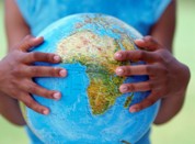 Child's hands holding globe showing map of Africa