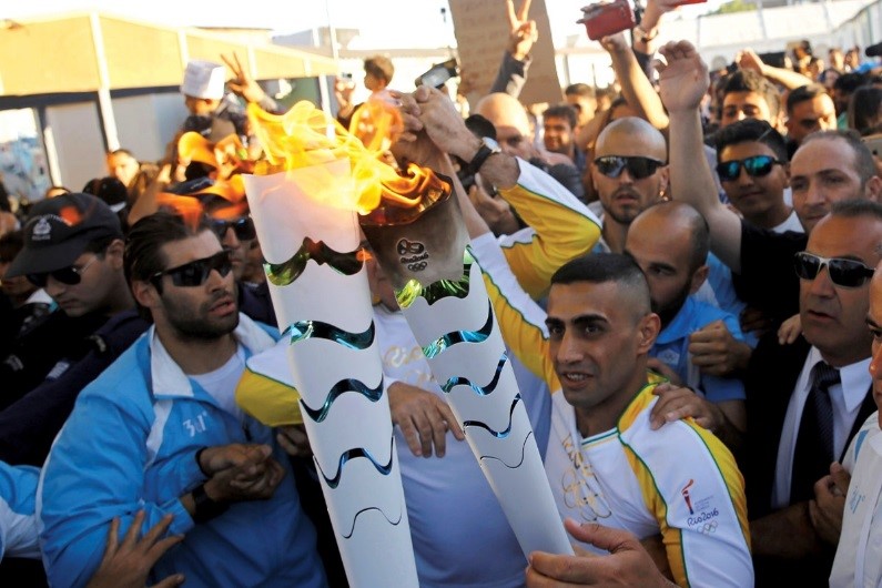 Ibrahim Al-Hussein carries the Olympic torch at the Eleonas refugee camp, Athens             Anadolu Agency